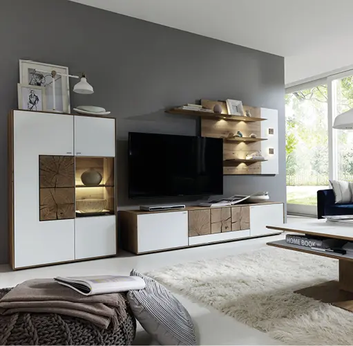 Wohnzimmer mit moderner Wohnwand in Weiß und Holzoptik, beleuchteten Regalen und großem TV – Wohnzimmereinrichtung mit Stauraum, Designmöbel in Naturtönen, Kombination aus Funktion und Ästhetik.